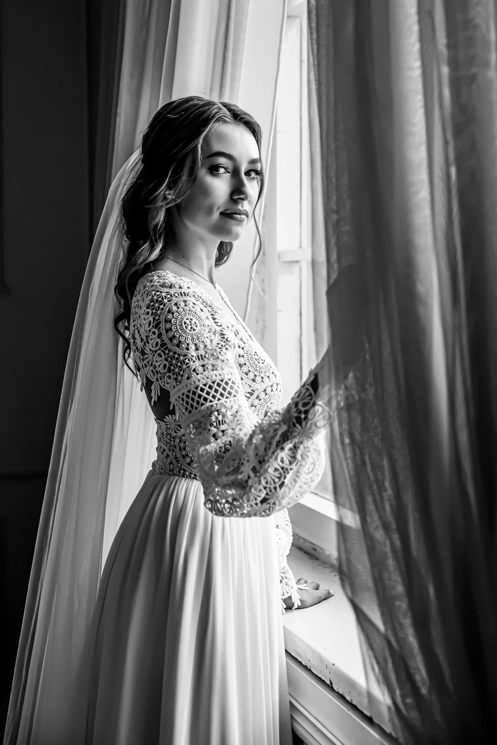 Wedding Portrait of the Bride in a Lace Dress by the Window.
